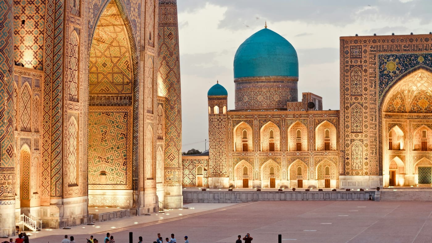 Registan Square in Samarkand, Uzbekistan — three illuminated madrasahs at dusk